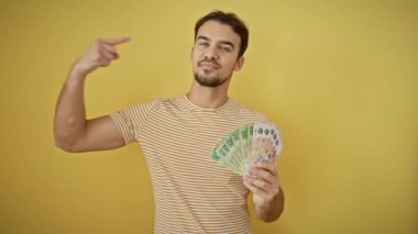 Şaşkın bir suratı olan neşeli, genç, İspanyol bir adam kendine güvenen, kendini gururla suçlayan. İzole edilmiş sarı bir duvara çizilmiş, mutlu ve inandırıcı bir gülümseme sergiliyor..