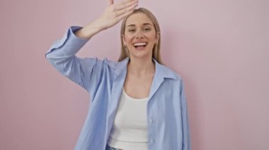 Neşeli, genç, sarışın bir kadın. Beklenti içinde gözlerini kapatıyor. Pembe arka planda şaşkınlıkla gülümsüyor.