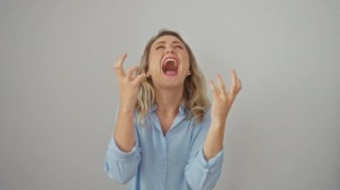 Öfkeli genç sarışın kadın, kolları havada, bağırıyor ve hayal kırıklığı içinde bağırıyor. Tişört giyiyordu. Yüzünde beyaz bir ifade vardı..