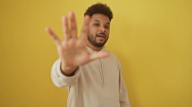 Neşeli Afro-Amerikalı kapüşonlu adam, 5 numarayı özgüvenle gösteriyor, mutlu bir şekilde gülümsüyor.