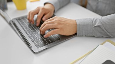 Genç Asyalı bir adam dikkatle bilgisayarının başında çalışıyor. Ofis ortamında, odaklanmış ve profesyonel..
