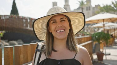 Arkaplanda geleneksel mimariyle Dubai çarşısını keşfeden gülümseyen kadın..