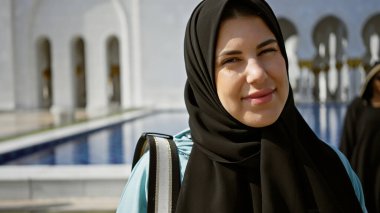Abu Dabi 'deki İslami camide tesettürlü genç, gülümseyen bir İspanyol kadın güzellik ve turizm gösteriyor..