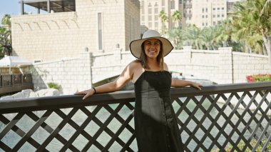 Güneş şapkalı gülümseyen kadın Dubai 'deki Suların ve Mimarinin tadını çıkarıyor.