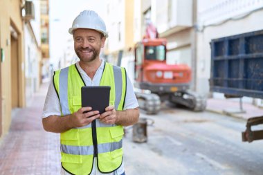 Middle age man architect using touchpad at street