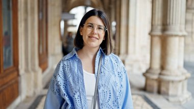 Viyana sokaklarında kendine güvenen güzel İspanyol kadın gülümsüyor.