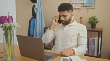 Modern bir ofis ortamında, sakallı genç bir İspanyol, akıllı bir telefonla konuşuyor. Sıradan profesyonelliği canlandırıyor..