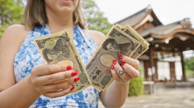 Kafkasyalı genç bir kadının elleri, Asya 'nın finansal zenginliğinin sembolü olan geleneksel jingu, kyoto' daki Japon yen paralarını sayıyor.