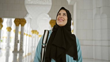 Abu Dabi 'deki camide altın kolonları taşıyan tesettürlü kadın.