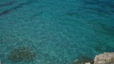 Salento, puglia, İtalya 'daki şiir mağarasında kayalık bir uçurumdan görülen berrak mavi su.