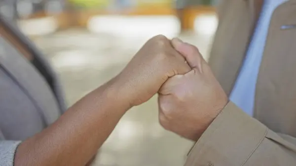 stock image Interracial couple holding hands affectionately in an outdoor urban environment, symbolizing love and unity.