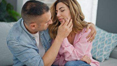 Erkek ve kadın çift evde birbirlerine sarılıp teselli veriyorlar.