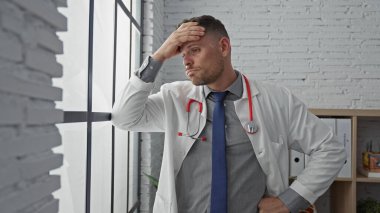 Steteskopu klinikte olan beyaz önlüklü endişeli İspanyol doktor.