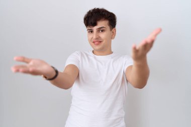 Gündelik beyaz tişört giyen, neşeli gülümseyen, yardım eli uzatan ve kabul gören genç, ikiyüzlü olmayan bir adam.. 