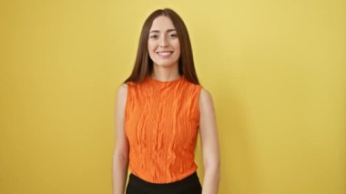 Kolsuz tişörtlü neşeli İspanyol güzeli izole edilmiş sarı stüdyo stüdyosuna 