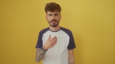 İğrençsin! Genç İspanyol adam ayakta, nefesini tutuyor, pis kokulu kokuya burnunu sokuyor, izole edilmiş sarı arka planda katlanılmaz bir tiksinti yayıyor.