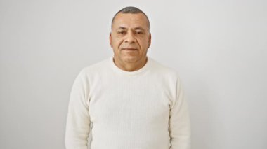 Neşeli orta yaşlı, dişlek sırıtışlı Latin bir adam kendine güvenir, izole beyaz arka planda kazak giyer.