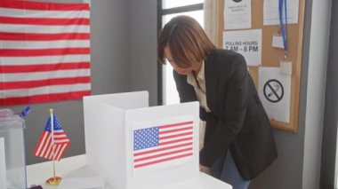 Afro-Amerikalı bir kadın bir Amerikan seçim merkezinde oy veriyor. Demokrasi ve vatandaşlık gösterisi yapıyor..
