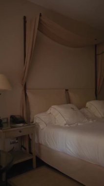 Zarif yatak odası, bej tenli, beyaz keten kumaşlı, ve sakin bir otel odasında klasik telefon..