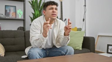 Heyecandan yumruklarını sıkan neşeli genç bir adam modern bir salonda gitar ile oturuyor..