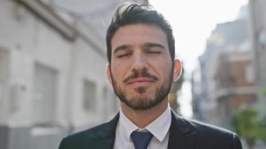 Yakışıklı, takım elbiseli, kenar mahallede güvenle gülümseyen adam.