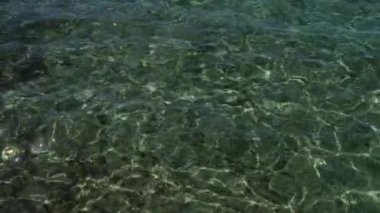 Porto sezaryen, İtalya, Puglia ve Salento 'da berrak, pırıl pırıl deniz suyu. Güneş ışığını büyüleyici ışık ve gölge desenleriyle yansıtıyor. Huzurlu ve sakin bir sahil sahnesi yaratıyor..