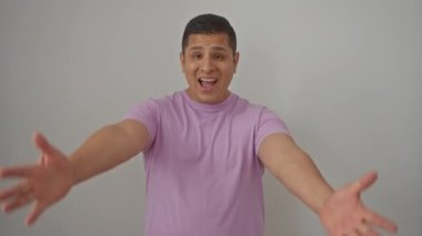 Işıl ışıl genç İspanyol adam kollarını açmış, neşeli mutluluğu somutlaştırıyor, izole edilmiş beyaz bir arka planda kameraya gülümsüyor.