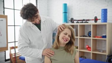 Fizyoterapist, modern klinikte kadının boyun ağrısını inceliyor.