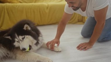 Neşeli, genç, İspanyol bir adam evcil köpeğiyle sıcak bir apartman dairesinde nişanlanıyor..