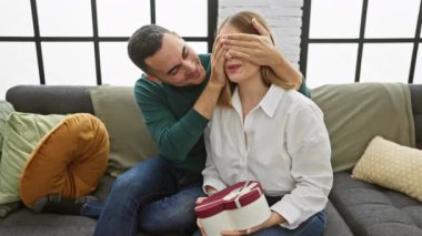 Erkekler, bir kadına hediyeyle hoş bir oturma odasında, sevgi ve neşe ileterek sürpriz yaparlar..