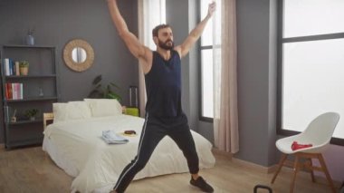 Yakışıklı sakallı adam modern yatak odası ortamında geriniyor.