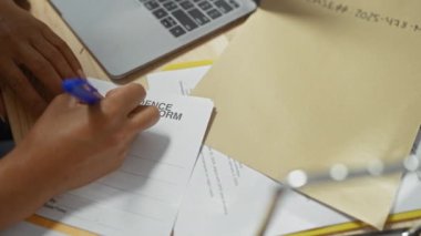 Bir kadın, polis soruşturma bürosundaki kanıt formlarını ve dava dosyalarını inceler..
