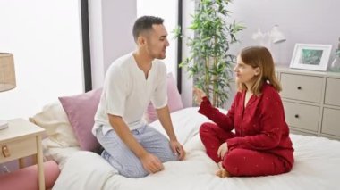 Pijamalı, sevgi dolu bir çift, samimi ve modern yatak odalarında keyifli bir anın tadını çıkarır..