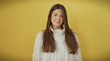Sevgi dolu bir öpücüğü üfleyen sevimli, genç İspanyol kadın, sarı arka plan altında eğlenceli, seksi bir jest.