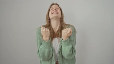 Zaferi kutlayan, gözlüklü, kolları havada, beyaz arka planda sevinçle bağıran muzaffer sarışın kadın.