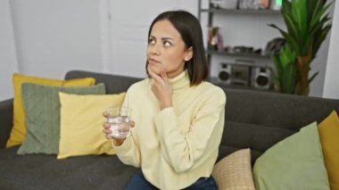 Bulmaca gibi soru, genç bir İspanyol kadının zihninde bir bardak su tutarak, güzel evinde güvenle gülümseyerek parmağını yukarı kaldırırken, hoş bir fikir uyandırıyor.