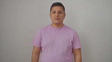 Neşeli genç İspanyol adam gülümsüyor ve yukarıya bakıyor, izole edilmiş beyaz bir arka plan üzerinde duruyor.