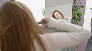 Soyunma odasında bir kadın aynanın önünde dikilirken mavi bir gömlek düşünüyor..