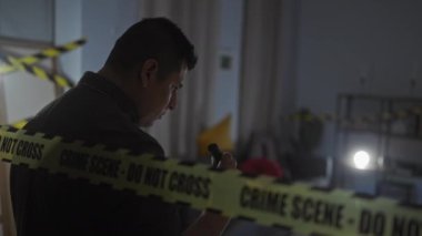 İspanyol dedektif kapalı mekan suç mahallindeki kanıtları dikkatli bir bantla analiz ediyor..