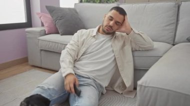 İspanyol bir adam rahat bir oturma odasında köpeğiyle kanepede dinleniyor.