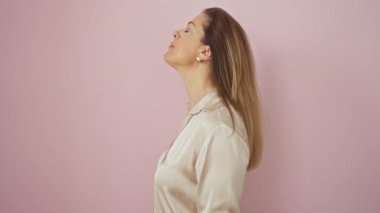 Sade gömleğiyle doğal güzelliğiyle hava atan kendine güvenen İspanyol kadın, pembe izole edilmiş arka planda neşeli bir gülümsemeyle gururla duruyor.