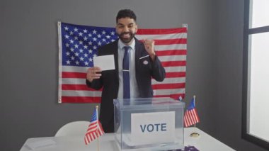 Genç İspanyol asıllı hükümet adayı başarıyı kutlamak için oylama yapıyor mutlu bir gülümseme ve Amerikan seçim kolejinde elini kaldırarak kazanan ifade.
