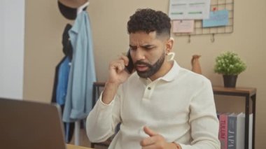 Modern bir dairede telefonla konuşan endişeli İspanyol bir adam..