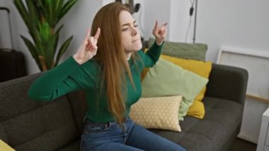Oturma odasında çılgın bir parti, çılgın genç bir kadın, elleri işaret eden kaya sembolü, içeride sallanan ağır müziğin sarışın yıldızı.!