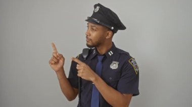 Sırıtan Afro-Amerikan polisi kameraya doğru bakıyor. Temiz beyaz bir arka planda ürün sunumu için mükemmel..