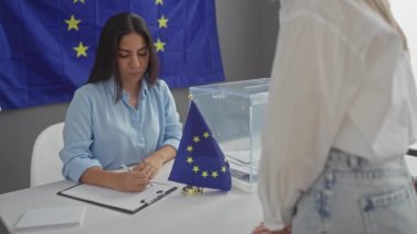 İki kadın, Avrupa 'da bir oy sandığında bir eu bayrağıyla süslenmiş bir oy sandığının önünde sohbet ediyorlar..
