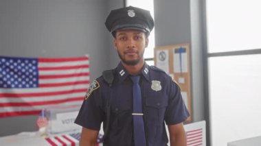 Üniformalı gülümseyen bir polis memuru, bayraklı bir Amerikan seçim merkezinde oy kullanma haklarını destekliyor..