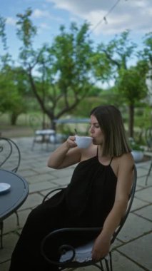 Genç bir kadın Puglia, İtalya 'da büyüleyici bir villada kahve içiyor. Etrafı yemyeşil ve resimli manzaralarla çevrili..