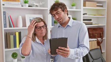 Kendine güvenen erkek ve kadın, iki güler yüzlü işçi iş yerinde konuşarak ve iş yerlerinde dokunmatik bir ortam kullanarak başarının tadını çıkarıyorlar..