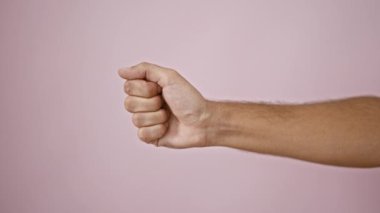 Pembe arka planda baş parmak hareketi ve baş parmak hareketi yapan bir adamın yakın çekimi..
